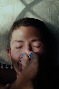 a man laying on a bed with his eyes closed